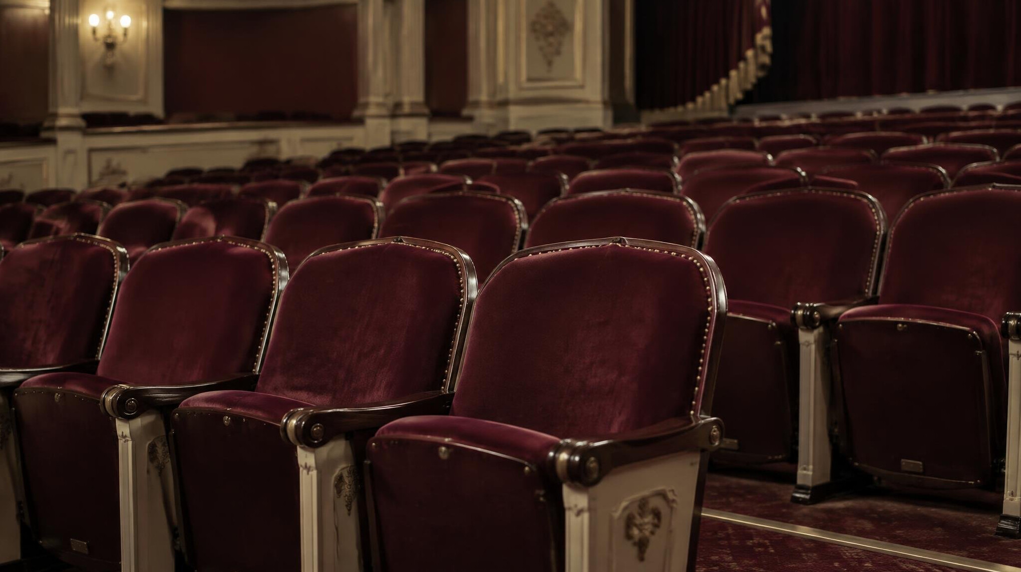 Reihen leerer Theatersitze in gedämpftem Licht