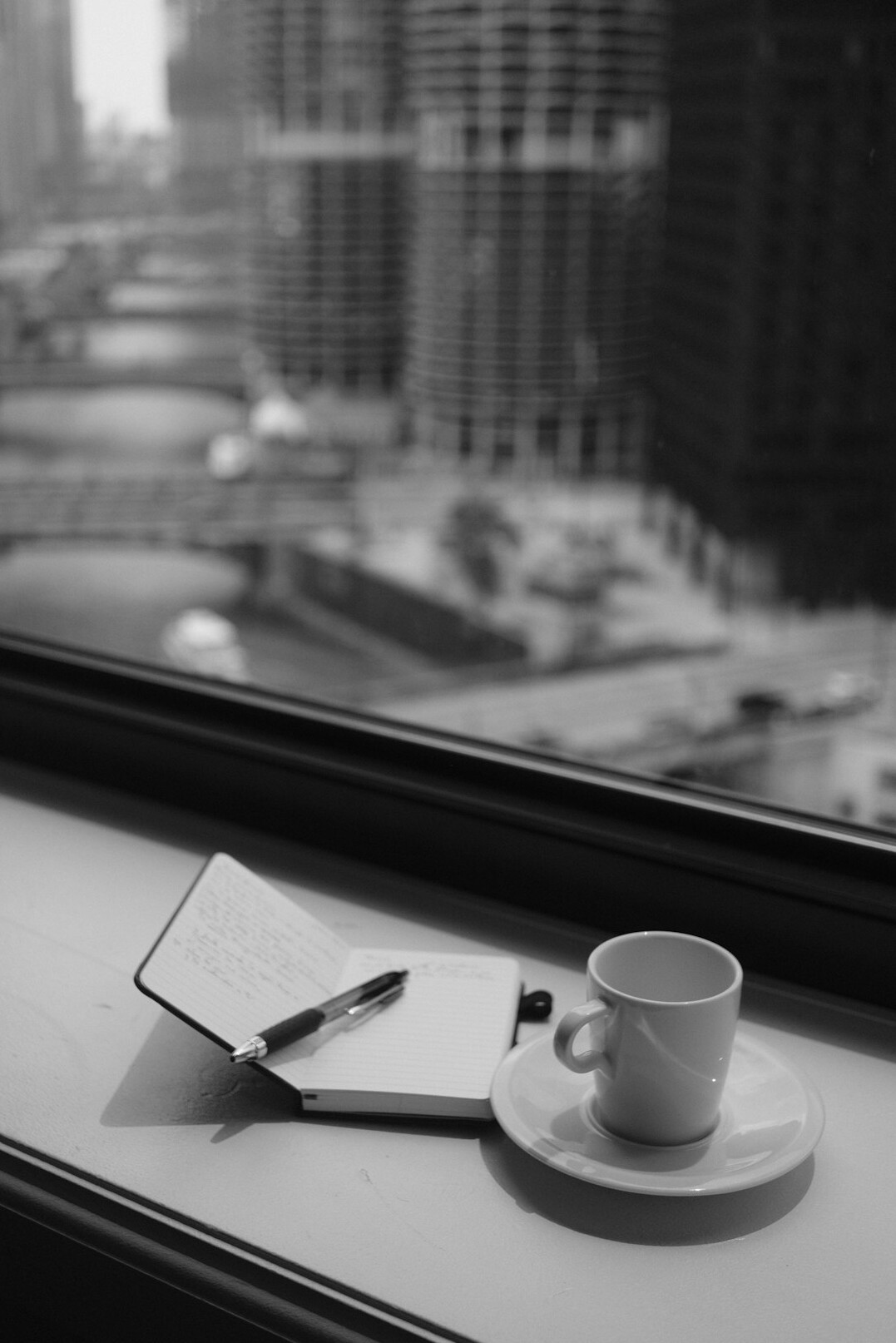 Minimalistischer Schreibtisch mit Notizbuch und Tasse nahe einem Fenster